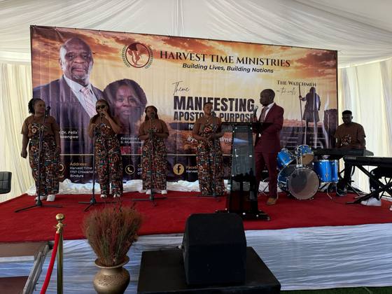 The praise team leading worship beneath the conference banner