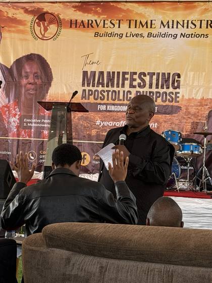 A minister praying for members of the congregation
