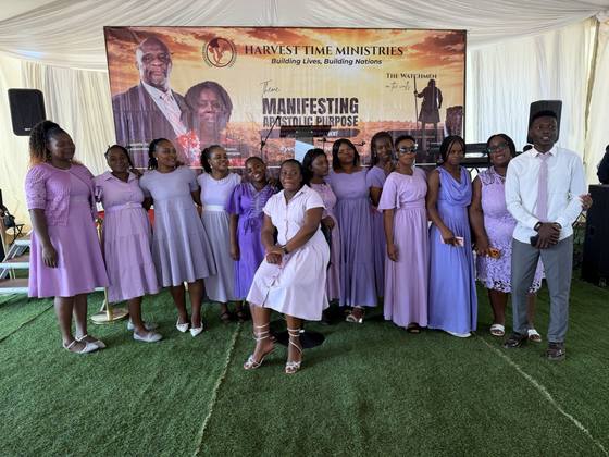 The choir in lilac gathered before the conference banner
